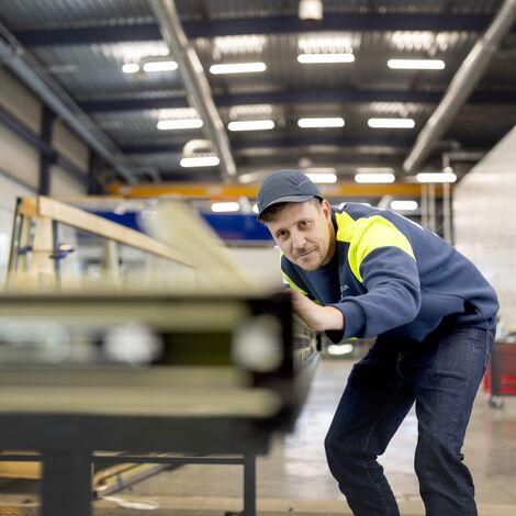 Виробник вирівнює віконні профілі в захисному спорядженні.