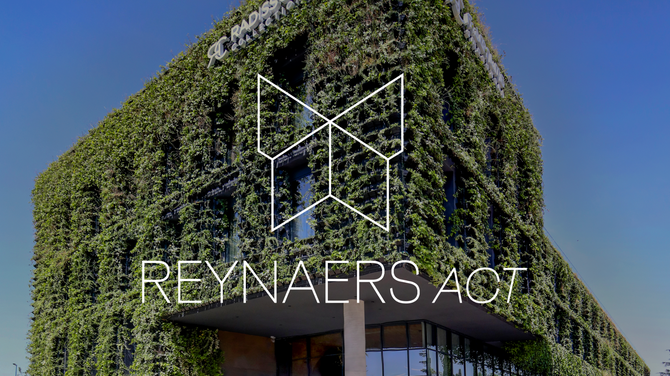 Логотип Reynaers Act на зеленому фасаді будівлі.